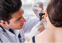 Doctor examining a patient's ear for ear wax removal