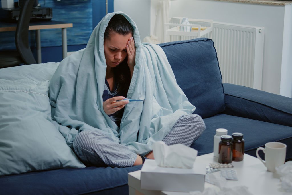 Woman with fever checking her temperature