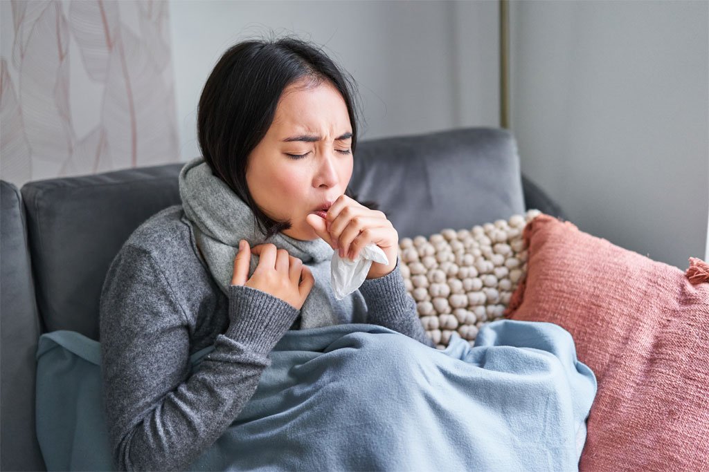 Woman coughing while feeling unwell