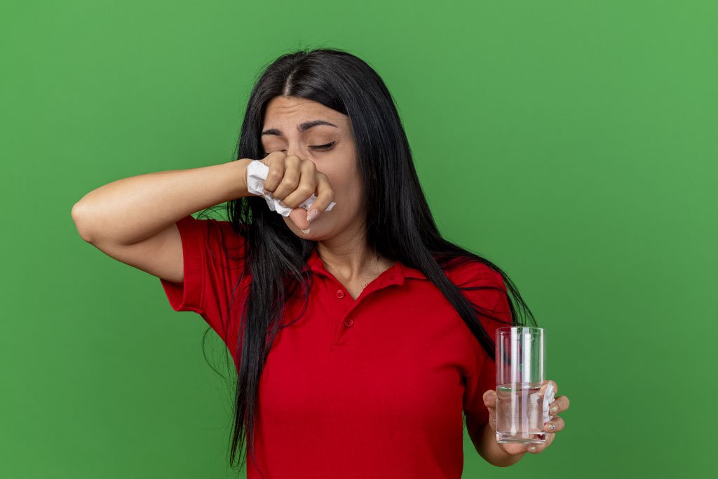 Woman taking medication while feeling unwell